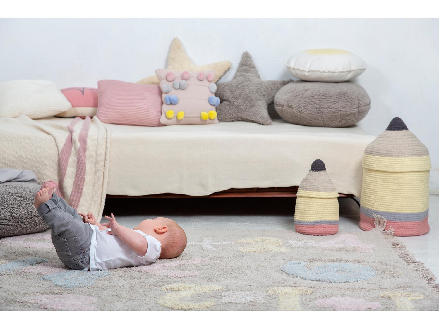 در این تصویر نوزادی را می‌بینیم که بر روی فرش ماشینی اناق کودک دراز کشیده و بازی می‌کند.